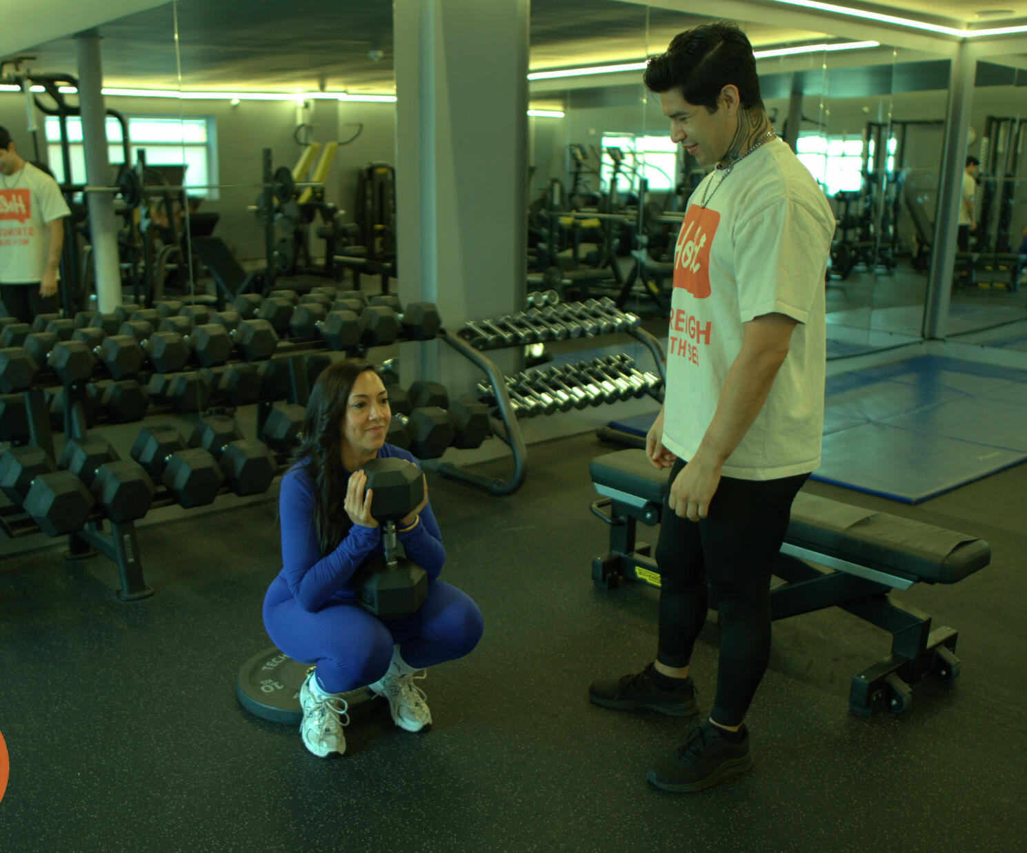 Seb, bilingual London personal trainer, coaching a female client through proper goblet squat technique during a strength training session.